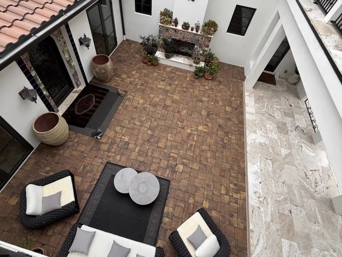 A brick paver courtyard seen from a balcony, after it was stripped, re-sanded and resealed.