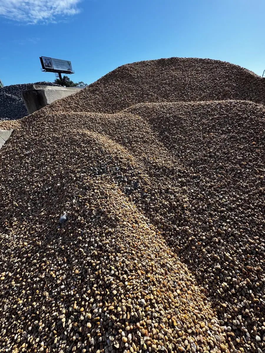 A pile of gravel delivered beside a house.