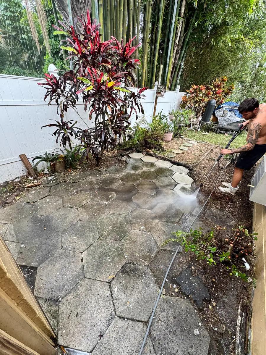 Laying hexagon pavers through a planted side yard.