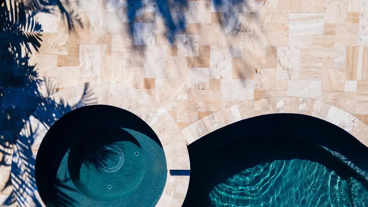 From above: two round pools set in a travertine deck.