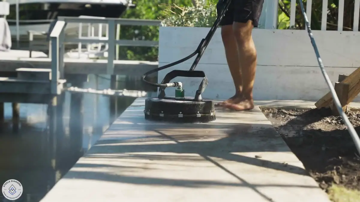A surface cleaner on a deck beside a dock and a boat lift.